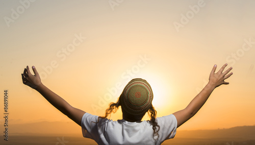 Photography a jewish scholar raising arms wide at sunset