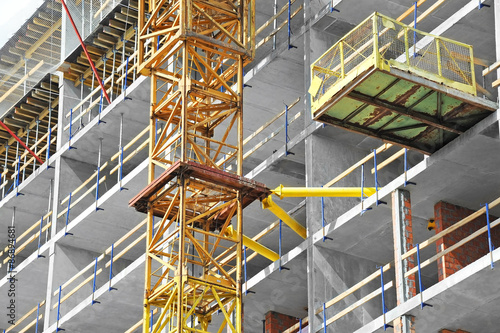 Crane and building construction site with balcony