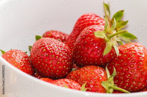 close up of white bowl with ripe strawberries