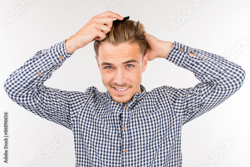 handsome young man brushing his hair