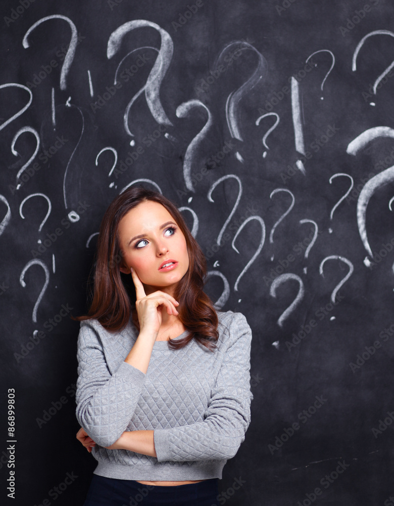 Young girl with question mark on a gray background Young girl with question mark on a gray background