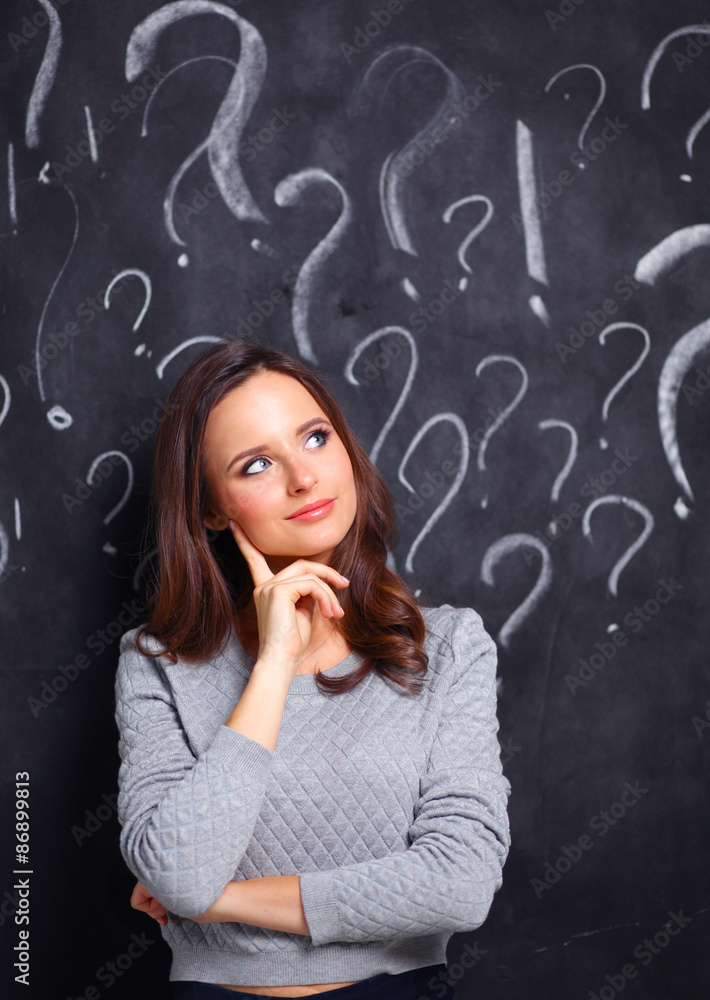 Young girl with question mark on a gray background Young girl with question mark on a gray background