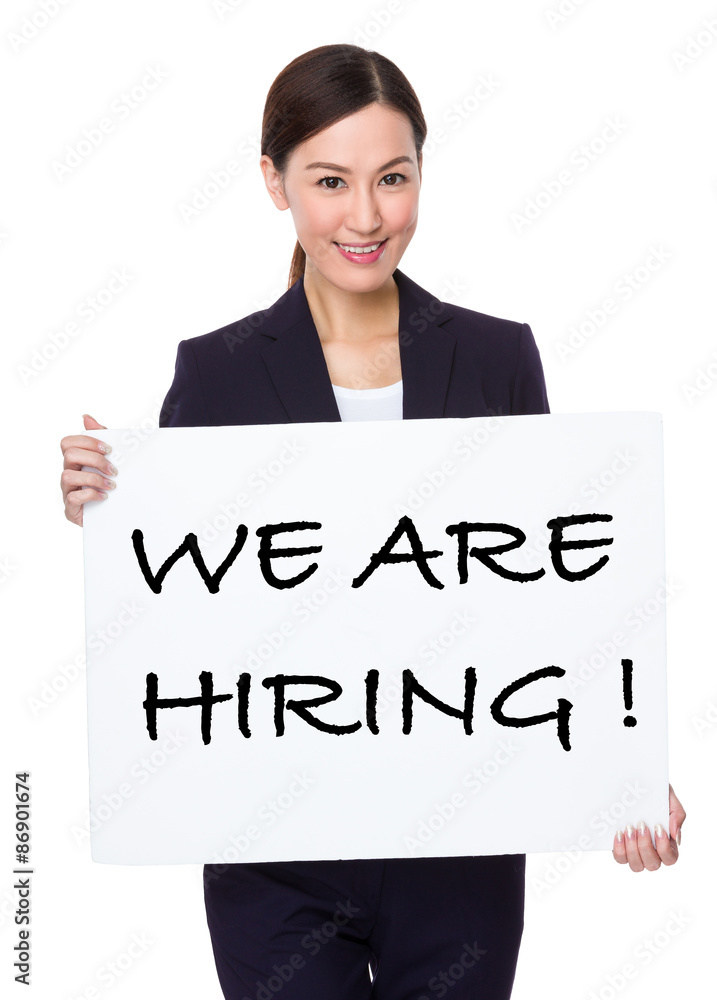 Businesswoman hold with a board showing phrase of we are hiring Businesswoman hold with a board showing phrase of we are hiring