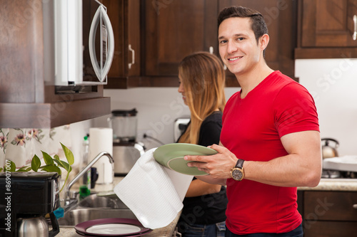 Obraz na plátně Man doing dishes with his girl