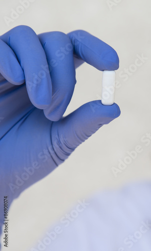 Doctor holding white pill capsules