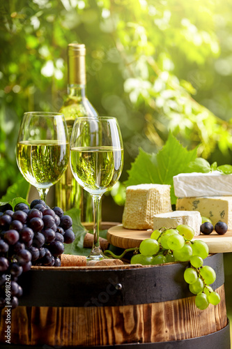 Old wooden barrel with bottle and glass of red wine.