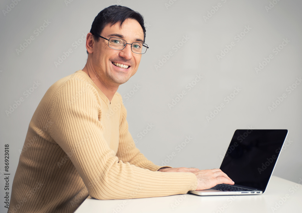 man sitting at desk, working on laptop computer man sitting at desk, working on laptop computer