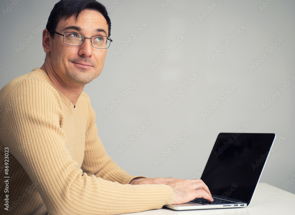 man sitting at desk, working on laptop computer man sitting at desk, working on laptop computer