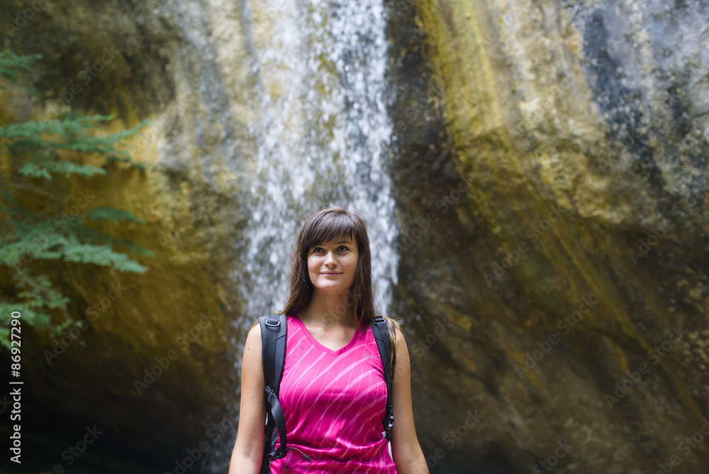 young caucasian female hiker near the waterfall young caucasian female hiker near the waterfall