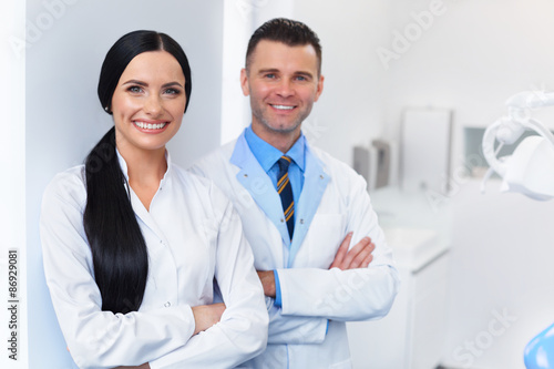 Dentist Team at Dental Clinic. Two Smiling Doctors at their Work photo