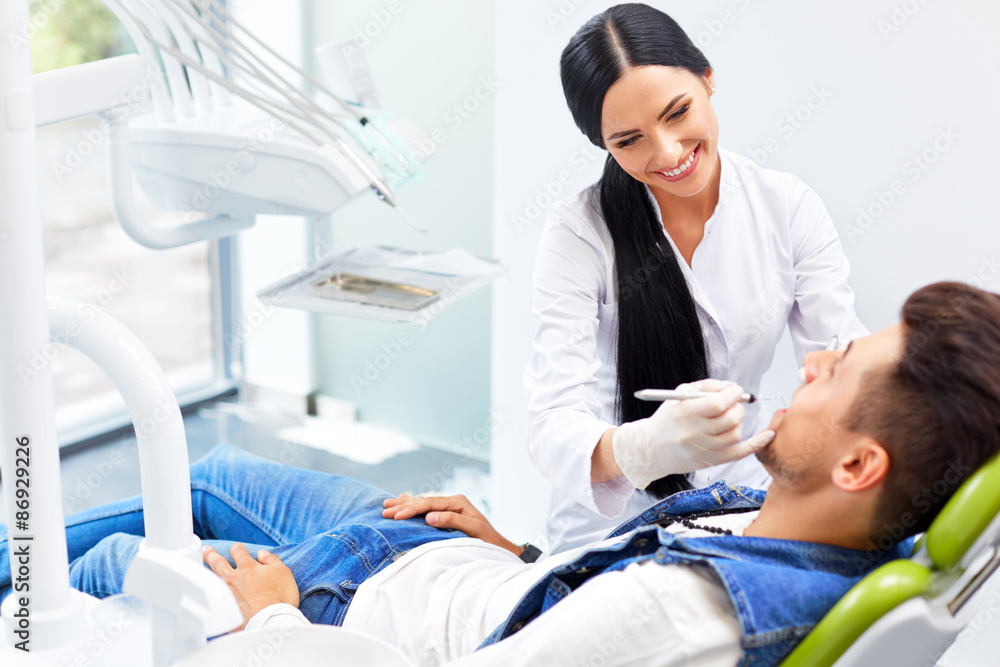 Obraz premium Famele dentist and man in dentists office. Dentist and Patient