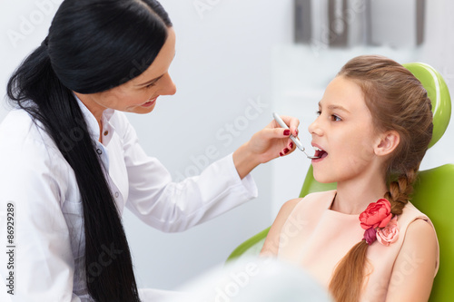 Teeth checkup at dentist s office. Dentist examining girls teeth