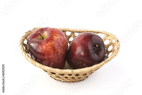 Two red apples in a wicker basket