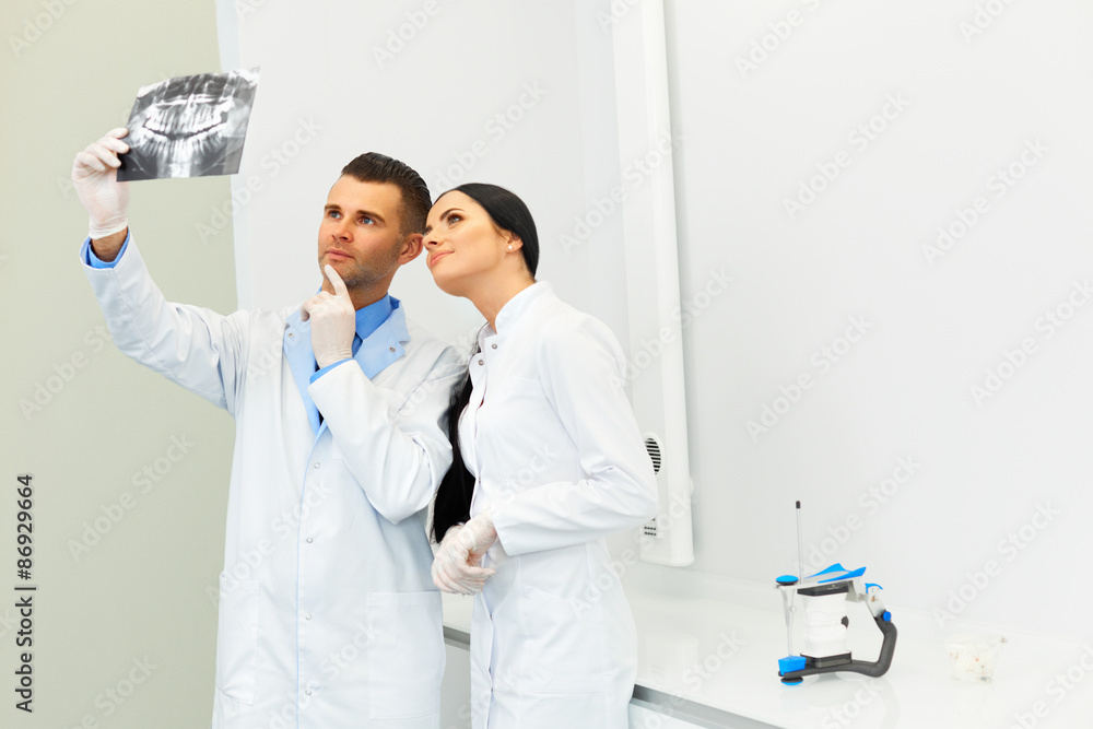 Dentist and female assistant are discussing dental X Ray image Dentist and female assistant are discussing dental X Ray image