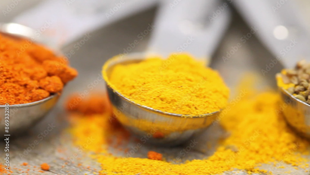 Various mixed spices (oregano, curcuma, paprika, anise) in metal scoops on wooden table Various mixed spices (oregano, curcuma, paprika, anise) in metal scoops on wooden table