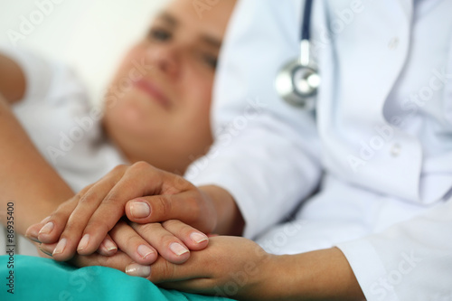 Friendly female doctor s hands holding patient s hand