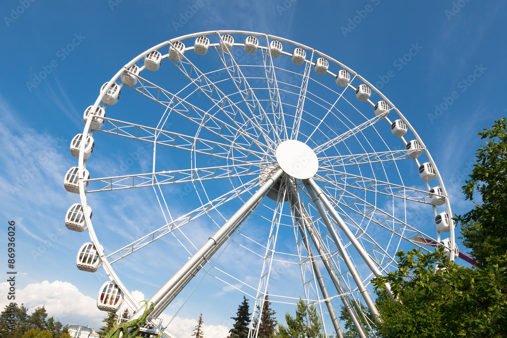 Fototapeta premium white ferris wheel against blue sky background