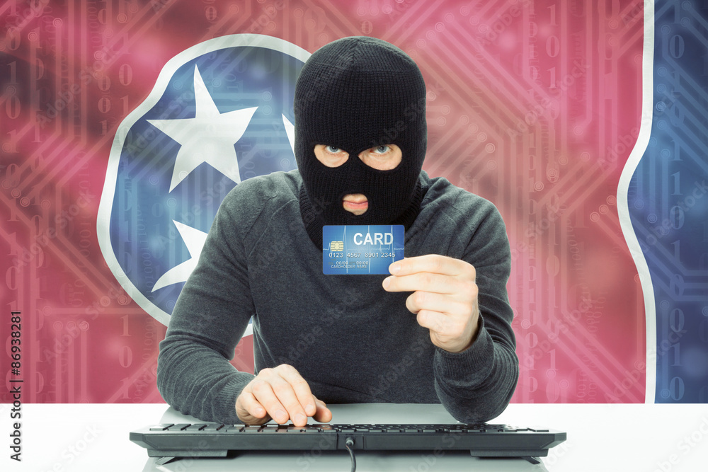 Hacker holding credit card and USA state flag on background - Tennessee Hacker holding credit card and USA state flag on background - Tennessee