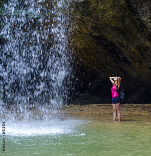 young caucasian female hiker near the waterfall
