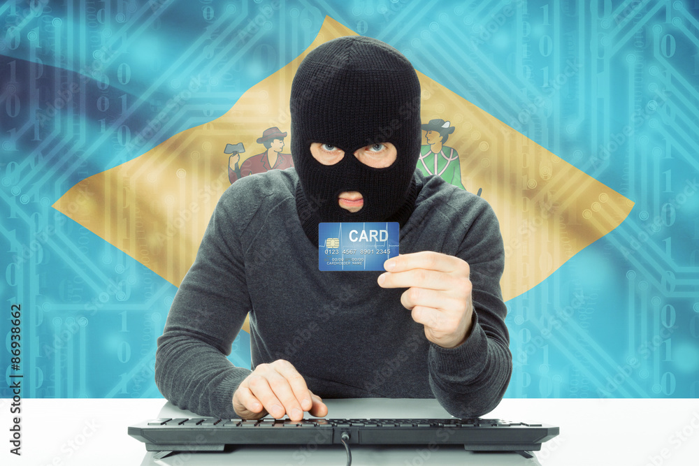 Hacker holding credit card and USA state flag on background - Delaware