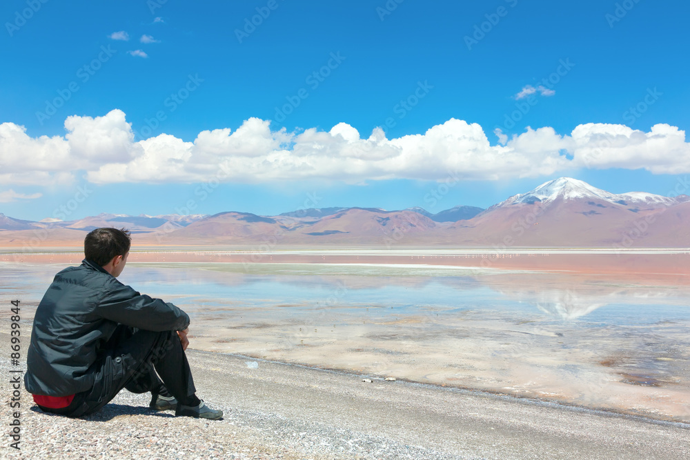 Man sitting alone on the shore of Laguna Colorada, Bolivia