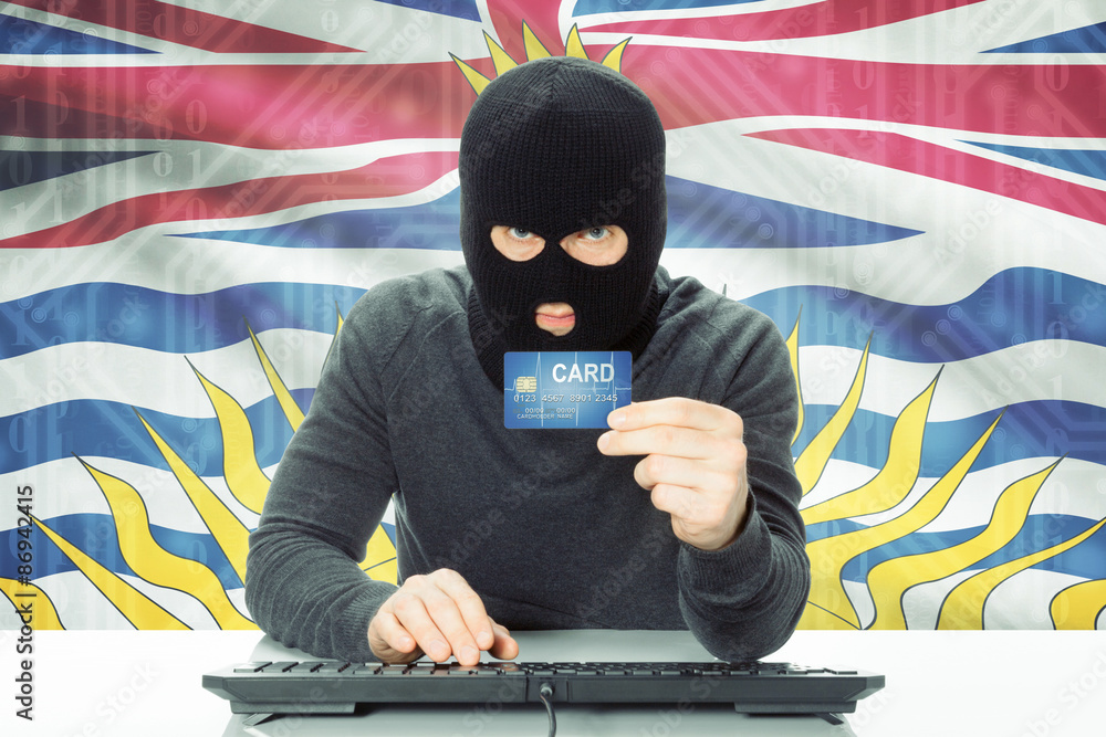 Hacker holding credit card and Canadian province flag on background - British Columbia Hacker holding credit card and Canadian province flag on background - British Columbia