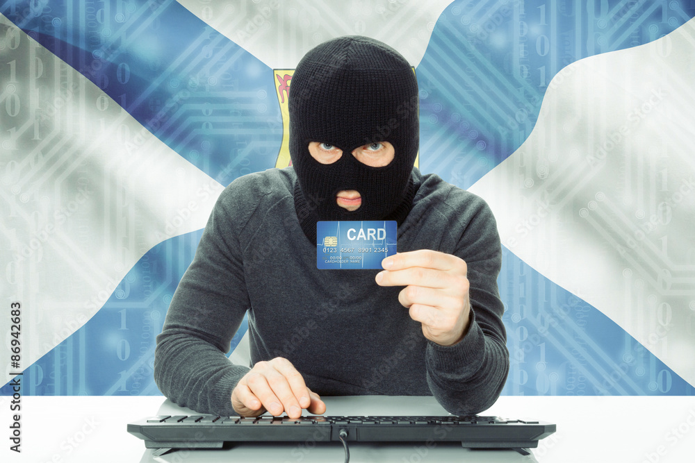 Hacker holding credit card and Canadian province flag on background - Nova Scotia Hacker holding credit card and Canadian province flag on background - Nova Scotia