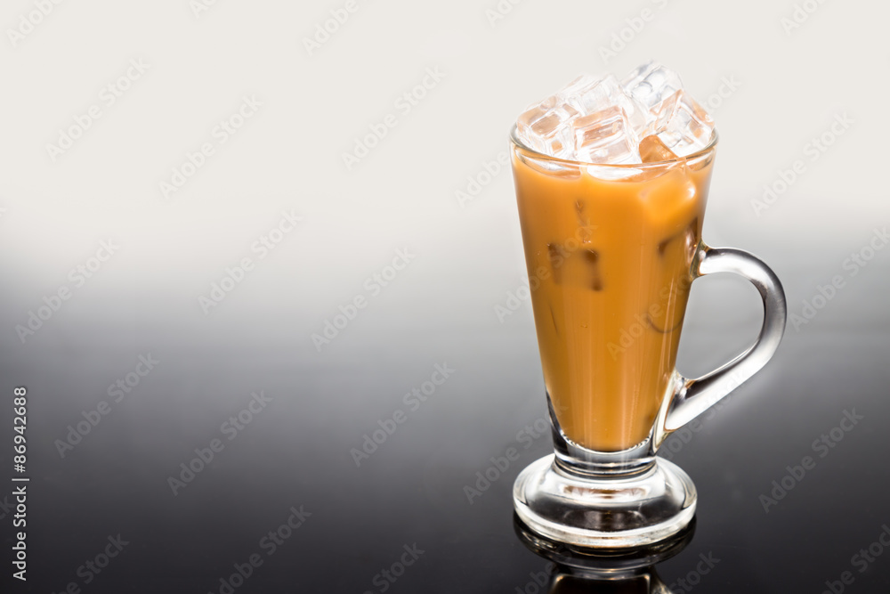 Refreshing ice cold coffee with milk in transparent glass flushed right Refreshing ice cold coffee with milk in transparent glass flushed right