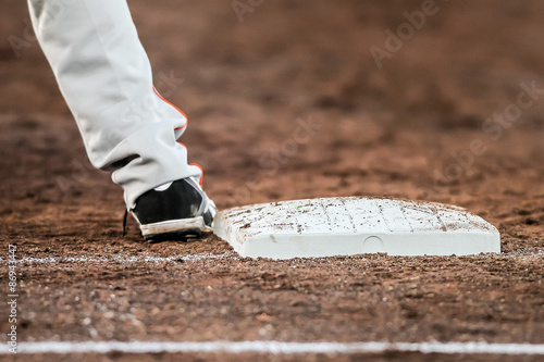 Baseball player with he's feet touching the base plate photo