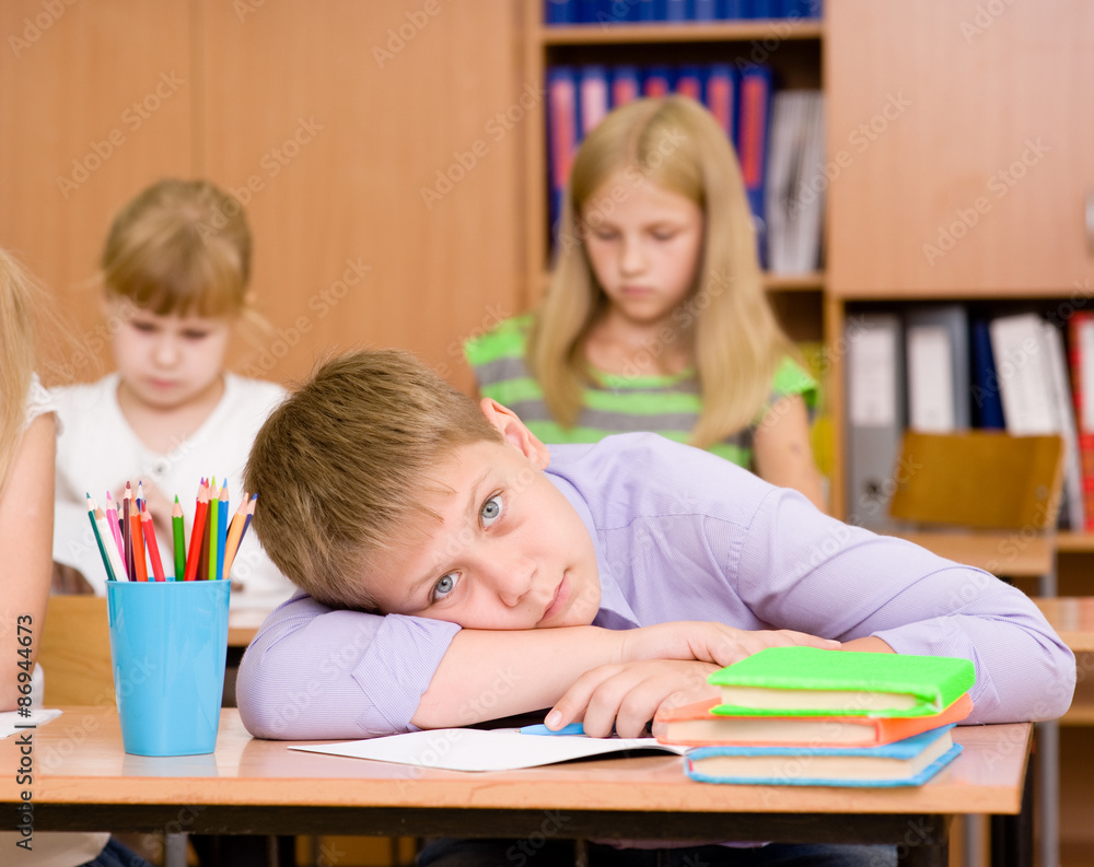 tired schoolboy at a lesson at school tired schoolboy at a lesson at school
