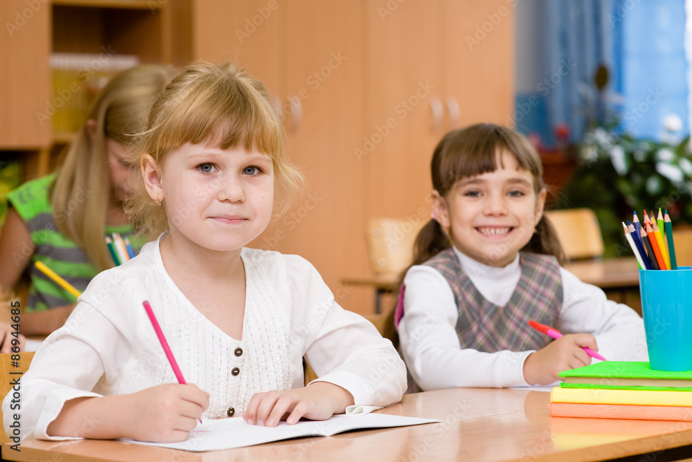 smiling schoolgirl looking at camera during lesson smiling schoolgirl looking at camera during lesson
