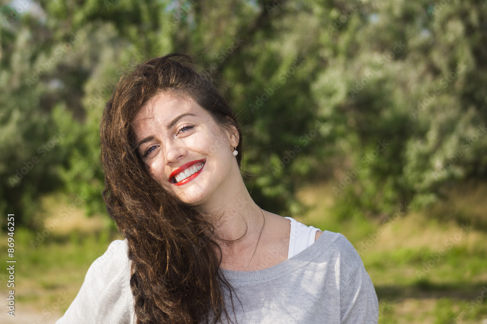 Portrait of smiling beautiful young woman close-up, against green of summer park Portrait of smiling beautiful young woman close-up, against green of summer park
