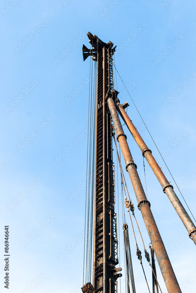 Obraz premium derrick in construction area against the bright blue sky