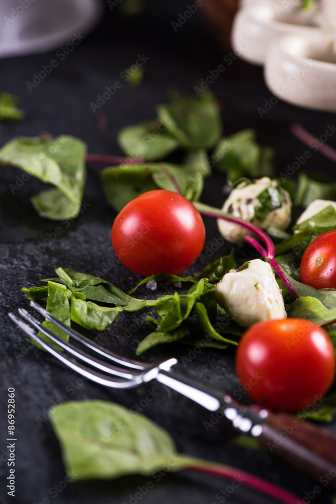 Fresh tomato and mozzarella salad on black slate Fresh tomato and mozzarella salad on black slate