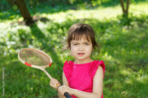 Girl with a badminton racket summer day