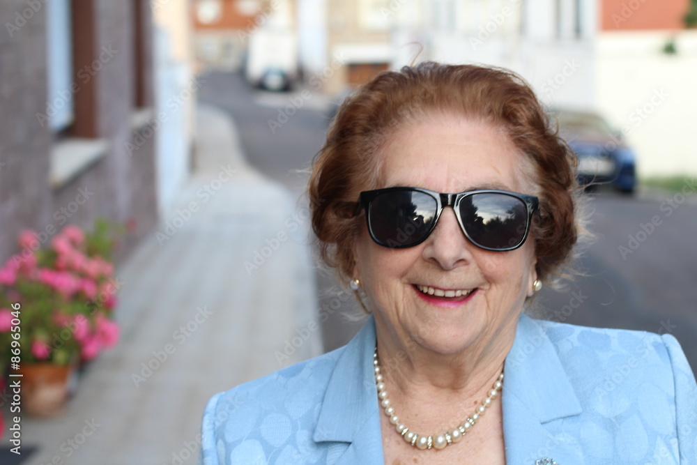 Portrait of a senior woman smiling and wearing sunglasses Portrait of a senior woman smiling and wearing sunglasses