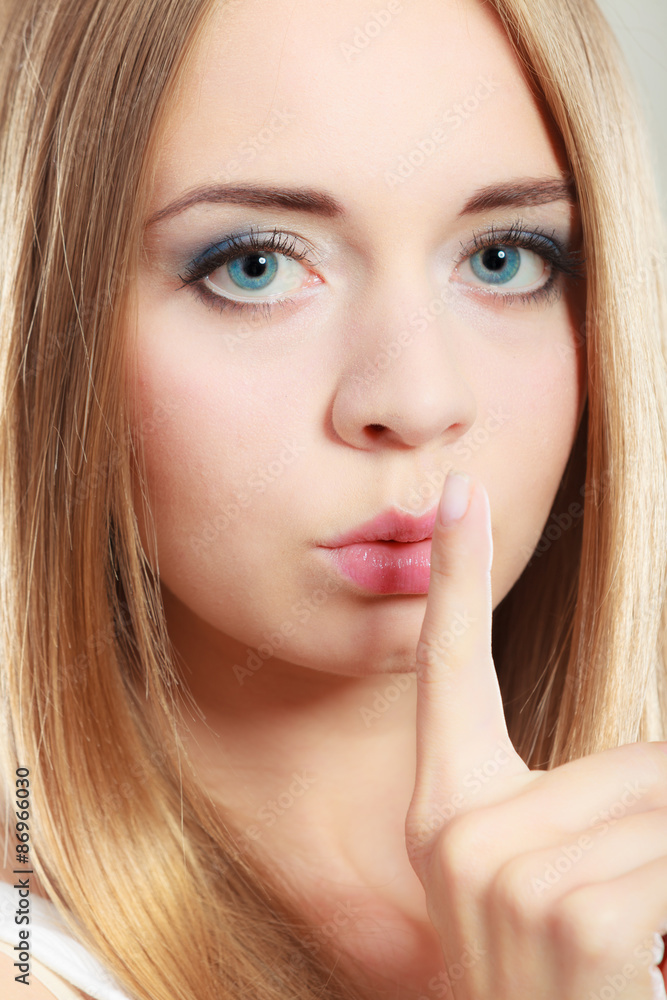 Woman asking for silence finger on lips Woman asking for silence finger on lips