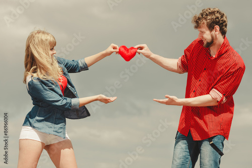 couple in love holds red heart outdoor