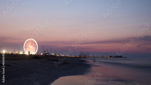 Ferris wheel in sunset on beach photo