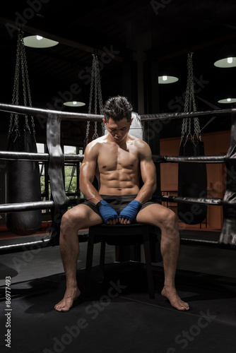 portrait of a young boxer sitting on his corner of the ring