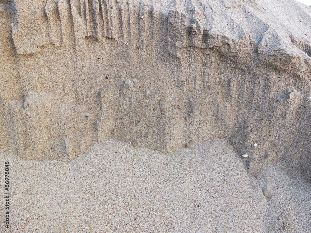 Fototapeta premium Closeup of sand pile for construction on a white texture backgro