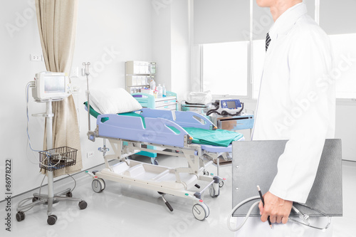 Doctor holding clipboard with stethoscope in hospital room