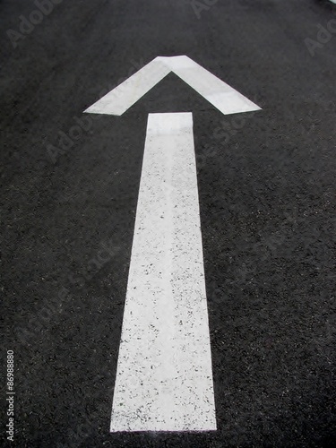 Asphalt road with a drawn direction arrow