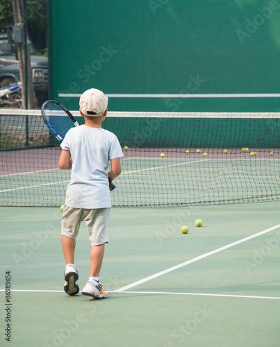 Little boy playing tennis on court © topntp