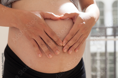 Wallpaper Mural Pregnant woman with heart hand Torontodigital.ca