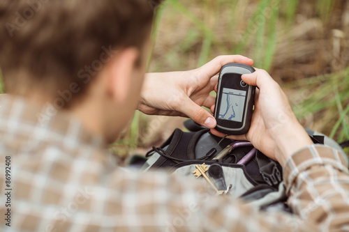 tourist  in the woods determines location using gps photo