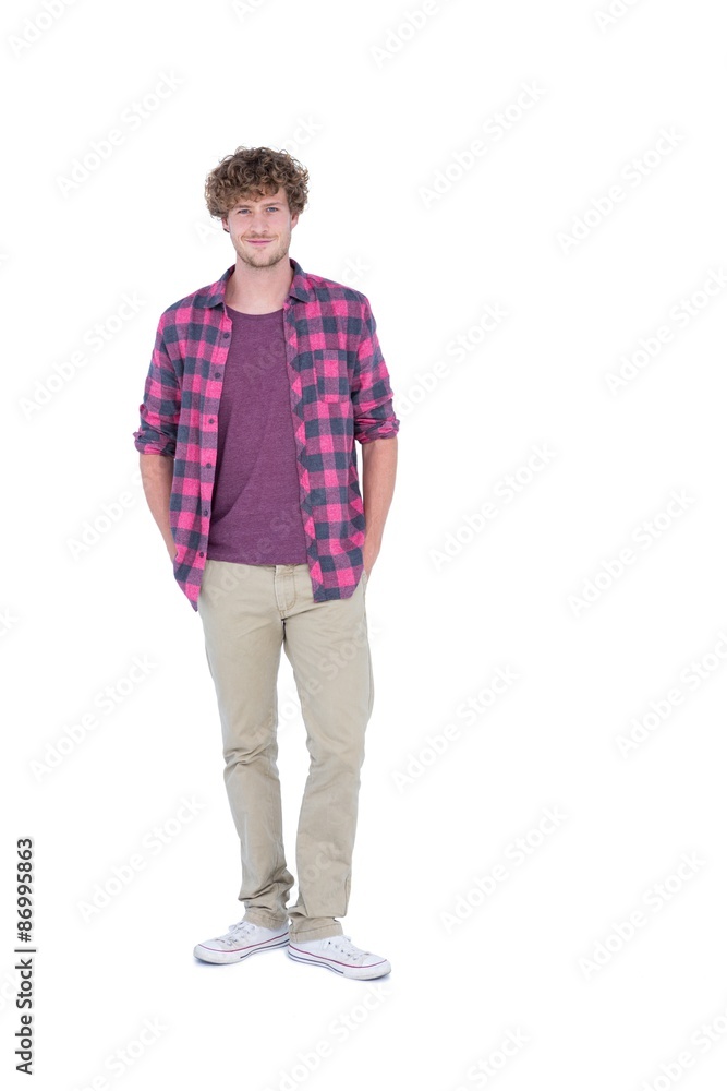 Happy handsome man looking at camera with hands in pockets Happy handsome man looking at camera with hands in pockets