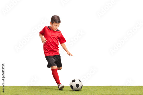 Little kid kicking a football