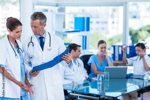 Doctors looking together at clipboard