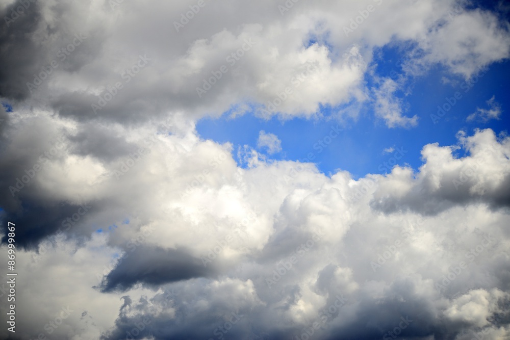 Big fluffy white and dark clouds in the blue sky Big fluffy white and dark clouds in the blue sky